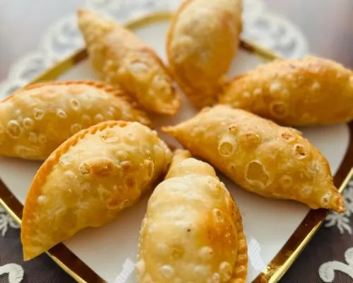 Golden fried gujiya on a plate